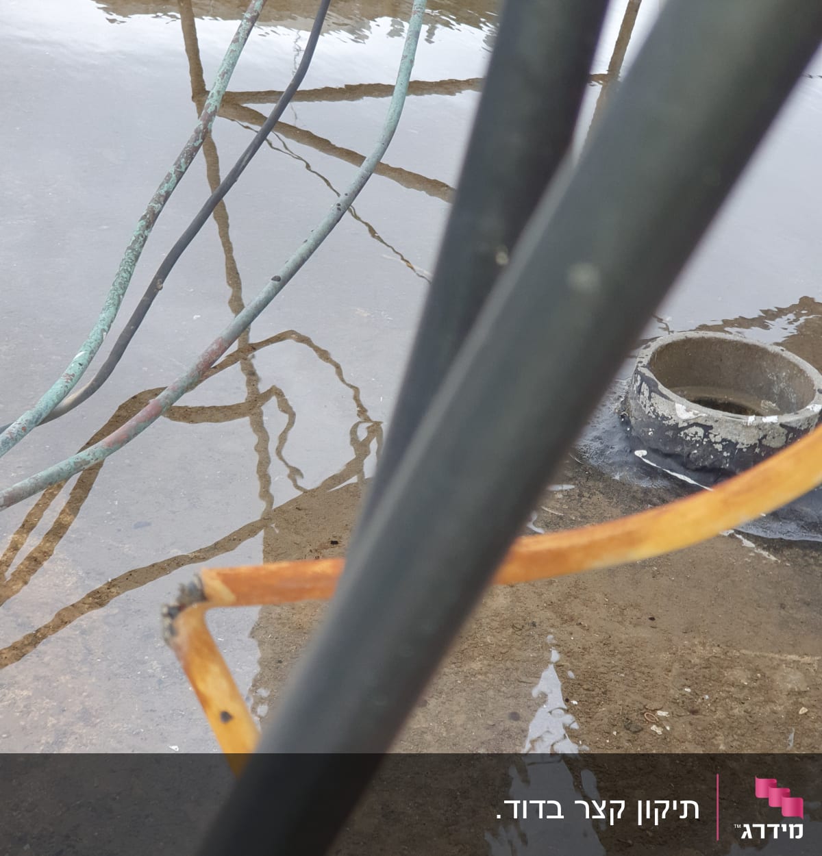 כבלים חשמליים על רצפה רטובה עם שלולית